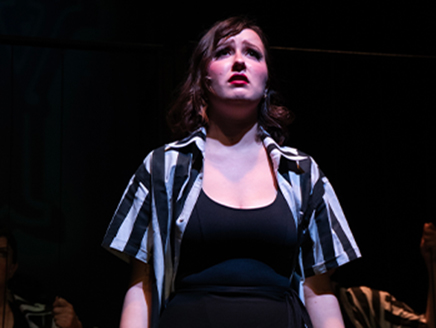 An image of Antonina looking emotional while performing on a stage.