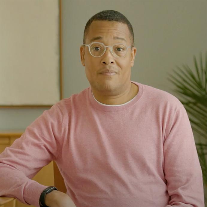 An image of Kevin Wake looking at the camera while wearing a pink shirt.