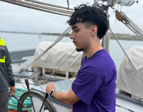 Julio, a Vertex Science Leaders Scholarship Recipient, steering a boat