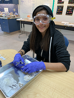 A girl wearing goggles working on a STEM project