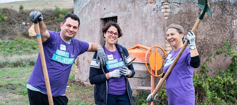 An image of 3 Vertexians in purple shirts holding garden tools