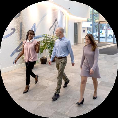 Three Vertex employees walking through the Vertex lobby in Boston