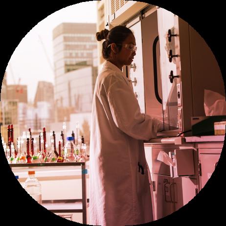 Female scientist at fume hood with city backdrop