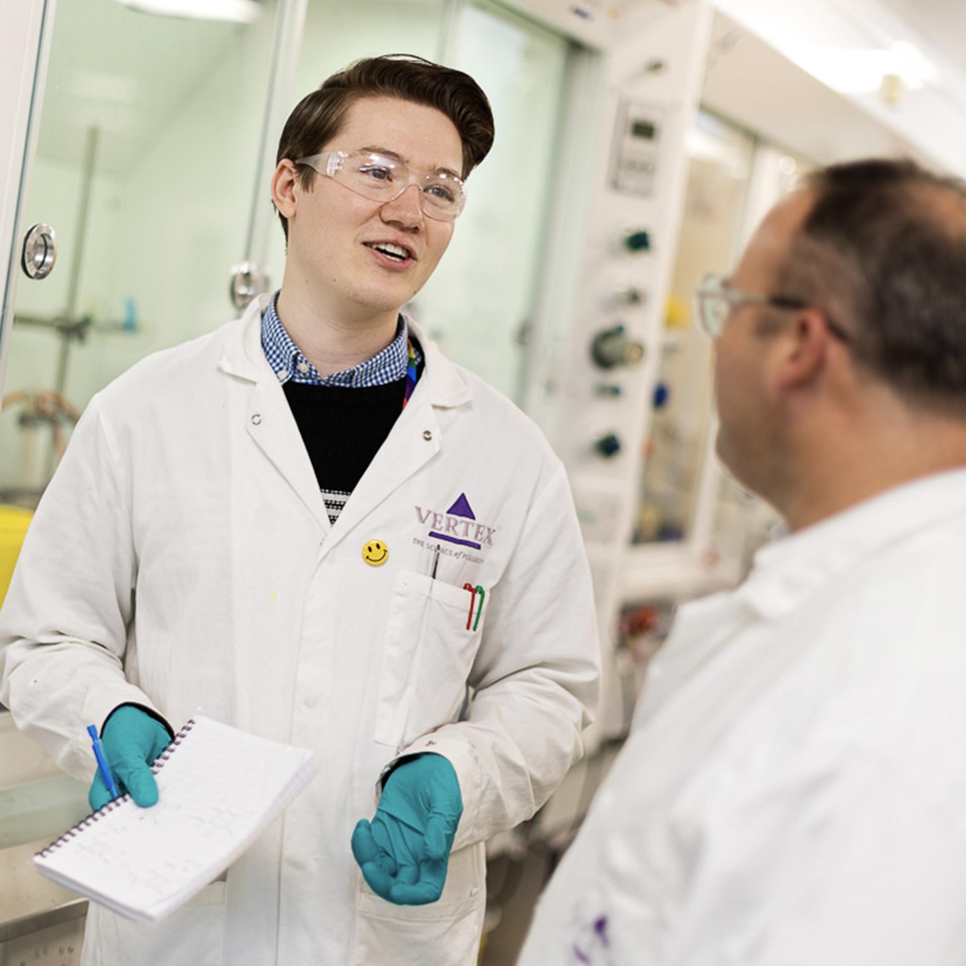 Two Vertex employees in labcoats working together