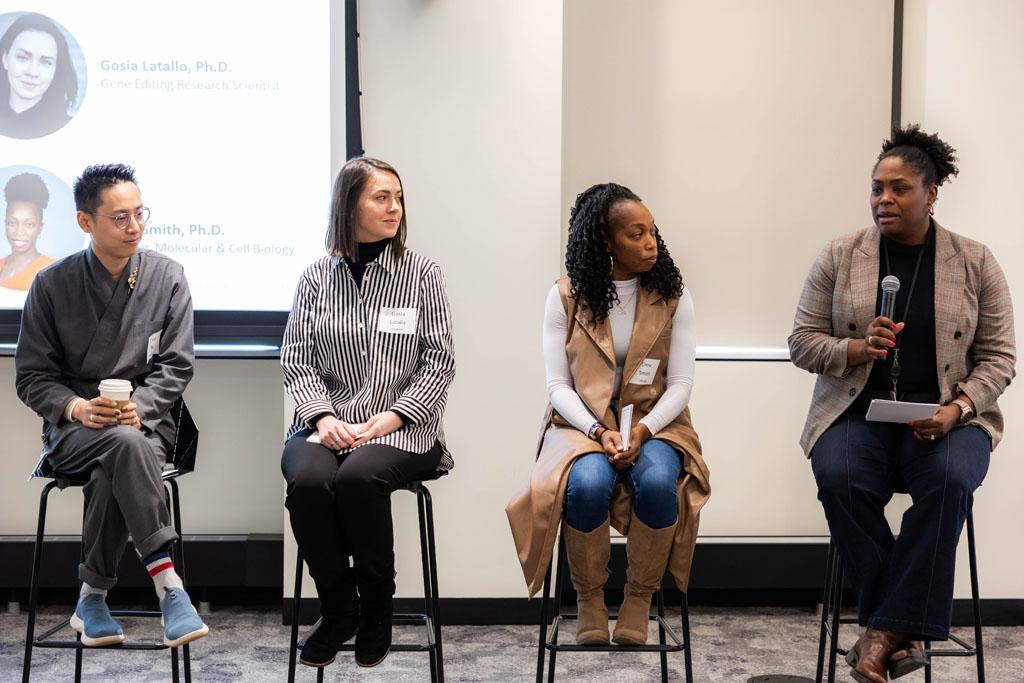 An image of four Vertexians sitting in chairs while speaking at a panel.