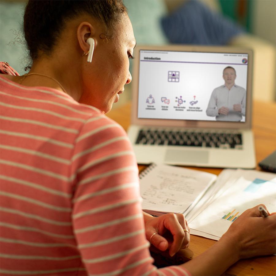 An image of someone sitting in front of a laptop with a Vertex University course on the screen