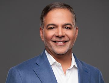 A headshot of Amit Sachdev, Executive Vice President, Chief Patient and External Affairs Officer at Vertex Pharmaceuticals