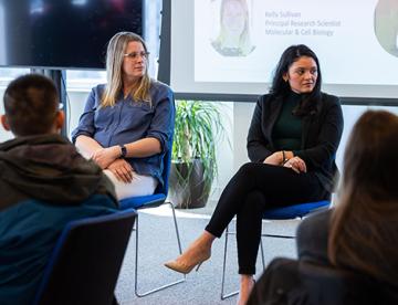 An image of a panel of women giving a talk about careers paths in biomedical science
