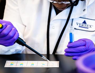 An image of a Vertex scientist using a pipette