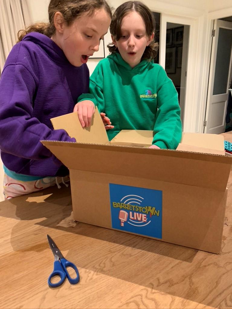 Two Barretstown campers open a box filled with activities