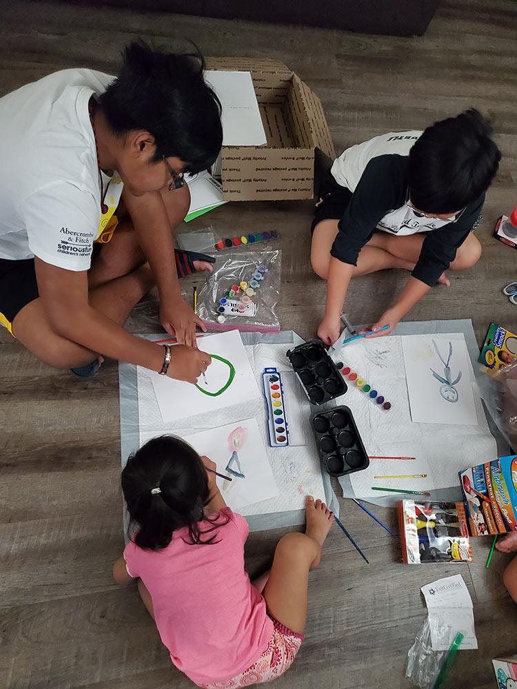 A group of children using paints on the fllor