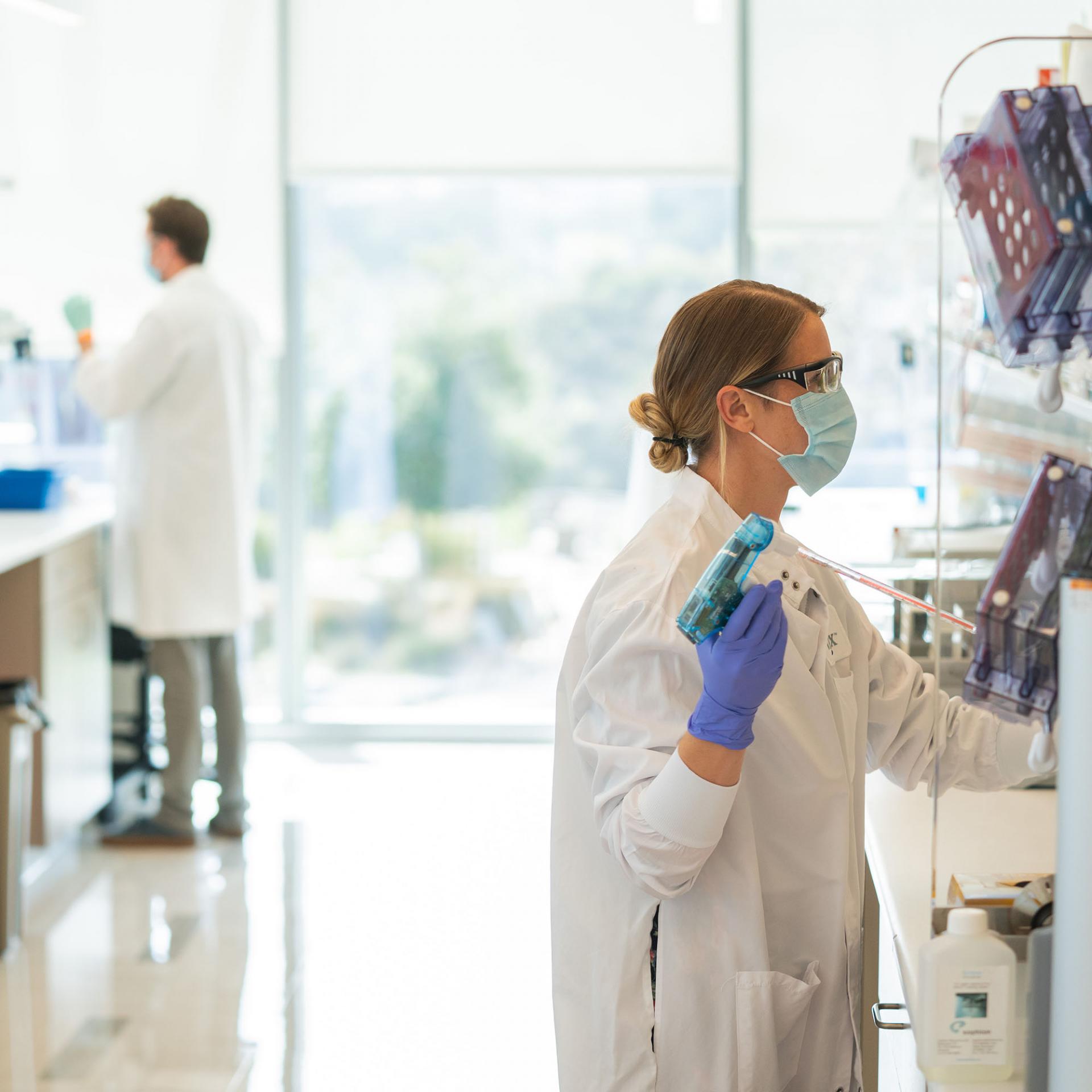 A female scientist working under the hood at the San Diego Vertex Pharmaceuticals research facility
