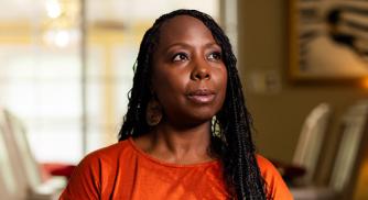 An image of Sharron Rouse wearing an orange shirt