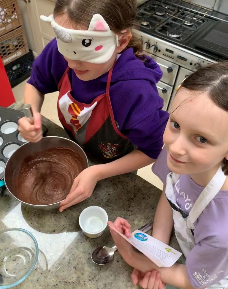 Two girls working on a baking recipe with Barretstown