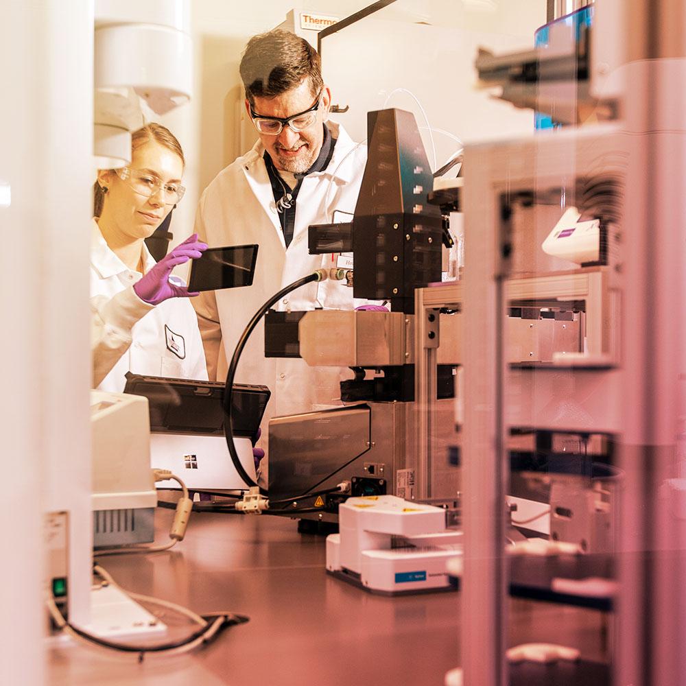 Male and female scientists observe scientific instruments