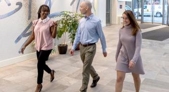 Three Vertex employees walking through the Vertex lobby in Boston