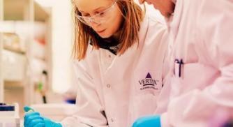 Two scientists working at a lab bench.