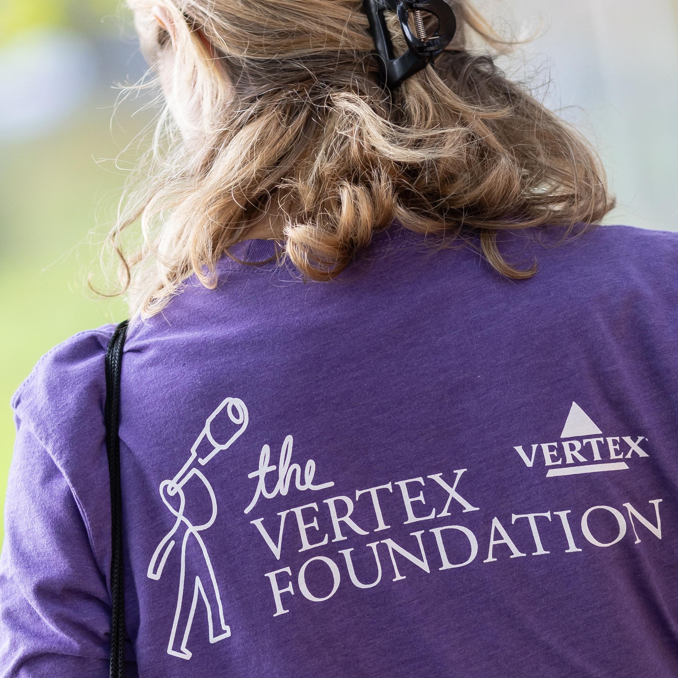 A Vertex employee wearing a purple shirt from the Vertex Foundation.