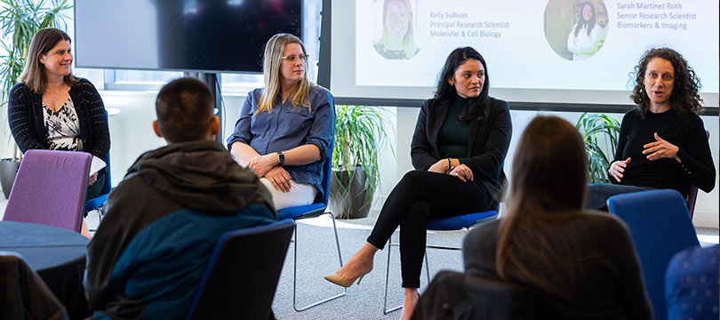 An image of a panel of women giving a talk about careers paths in biomedical science