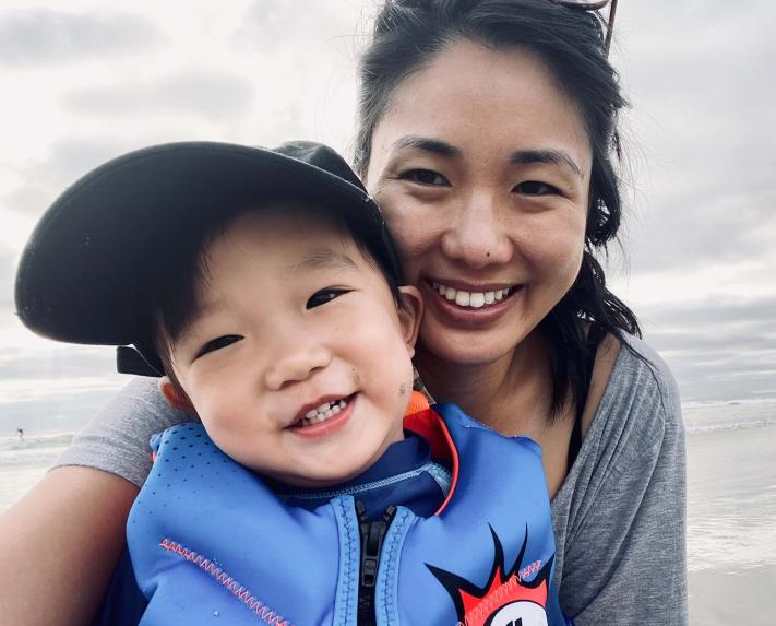 A mother and son pose for a selfie at the beach