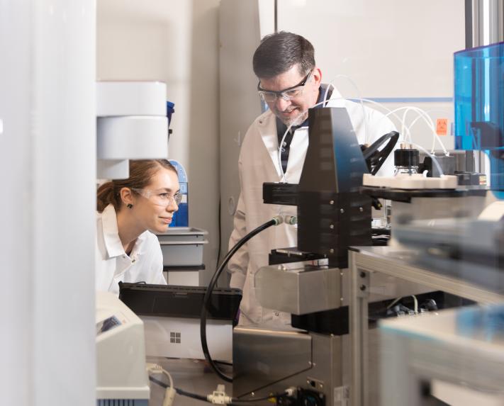 A male and female scientist looking at a computer screen in the lab