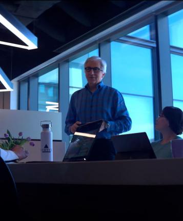An image of coworkers holding a meeting around a long table with a Vertex water bottle resting on the table