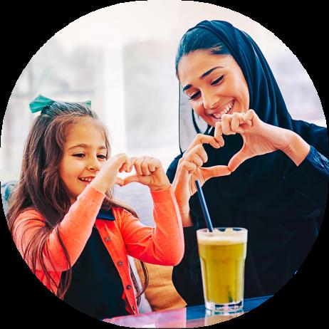 A mother and daughter making heart shapes with their hands
