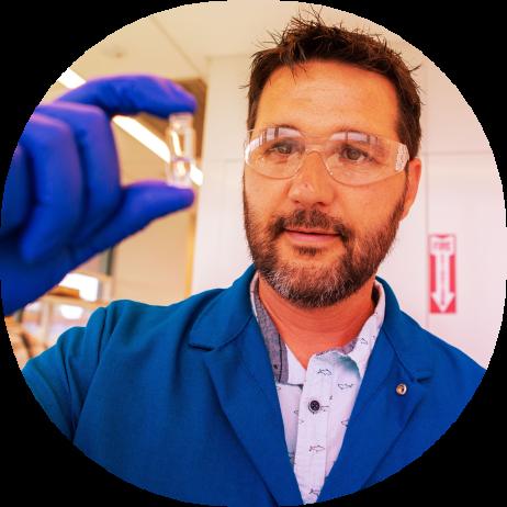 male scientist holding small test tube