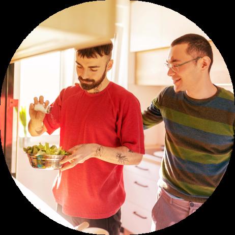 An image of two men in a kitchen preparing a salad