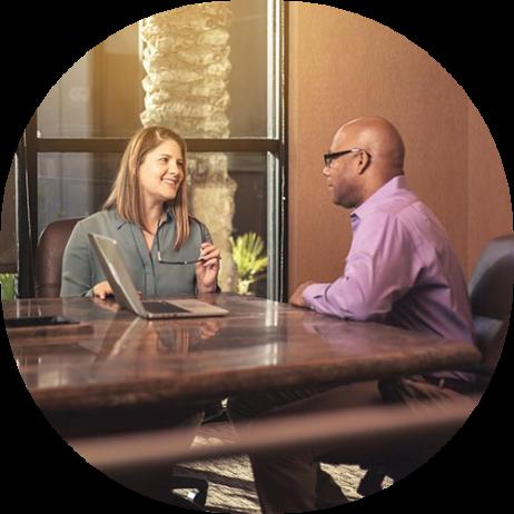 An image of a man and a woman at a conference table having a conversation