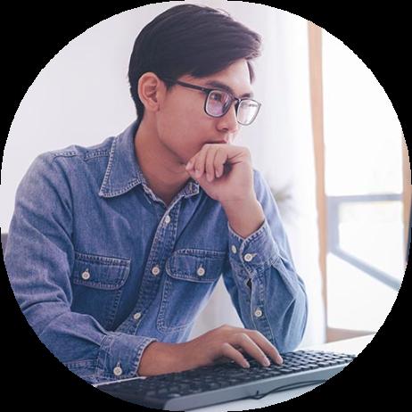 An image of a man in a blue shirt at a keyboard