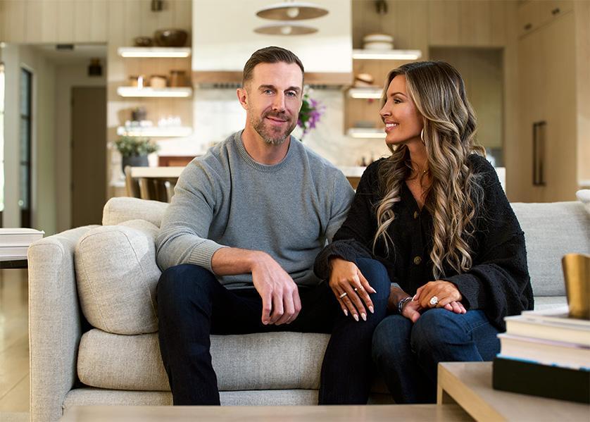 An image of Alex and Elizabeth Smith sitting on a couch. Elizabeth is looking at Alex while both are smiling.