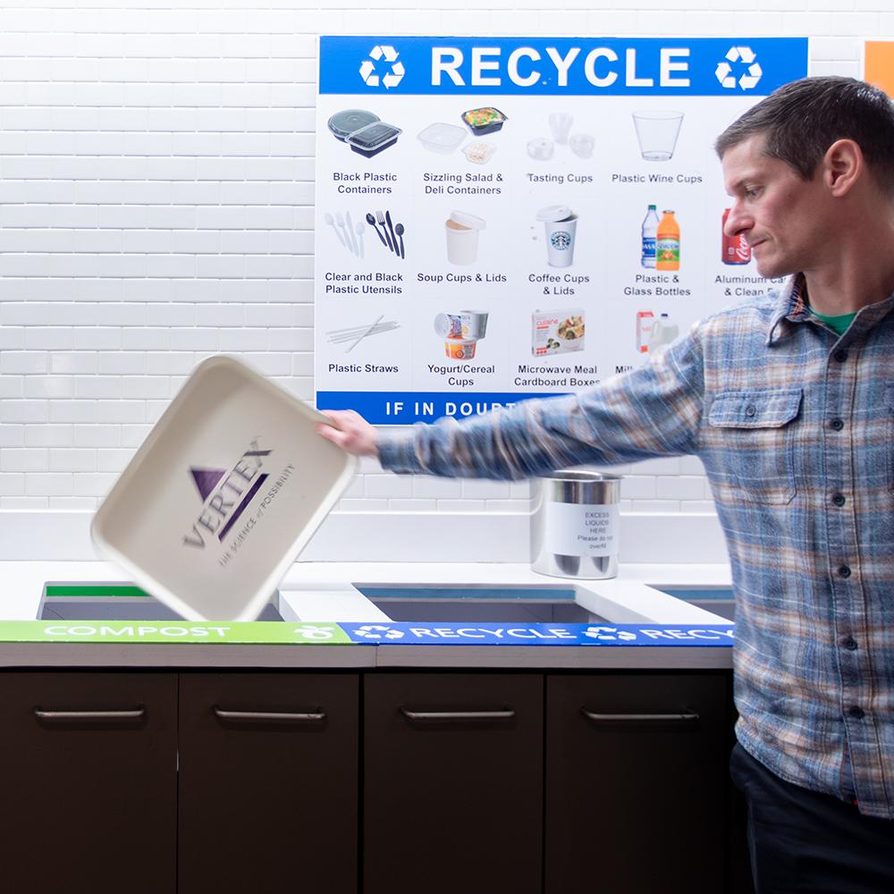 Vertex employee throws food scraps in the compost bin at the Vertex headquarters