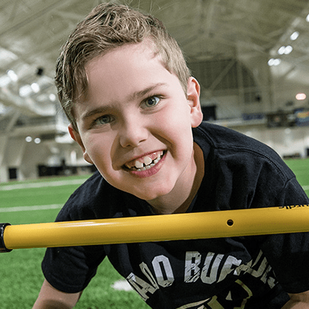 A smiling young boy on an indoor sports field