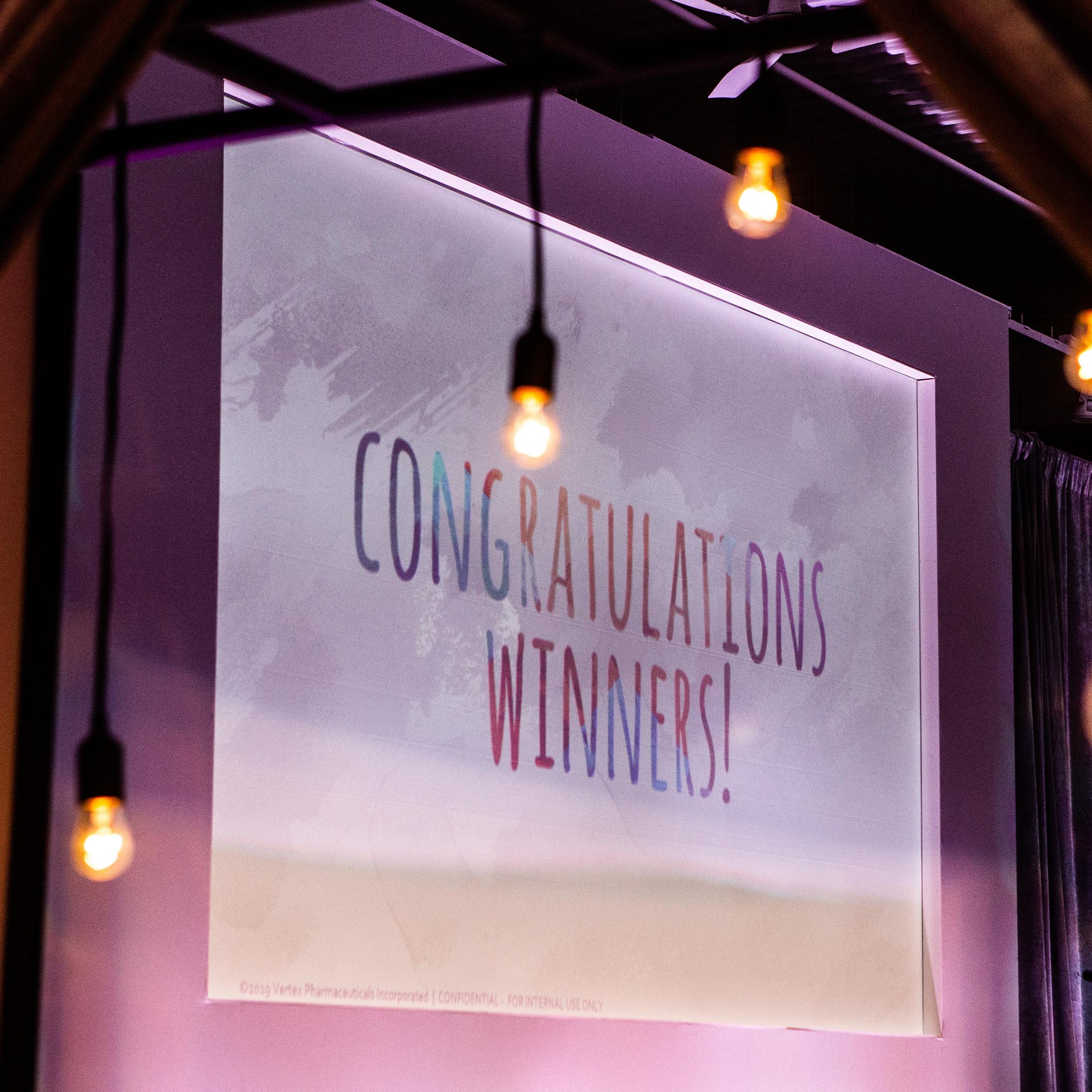 An image on a screen says "Congratulations, winners!"